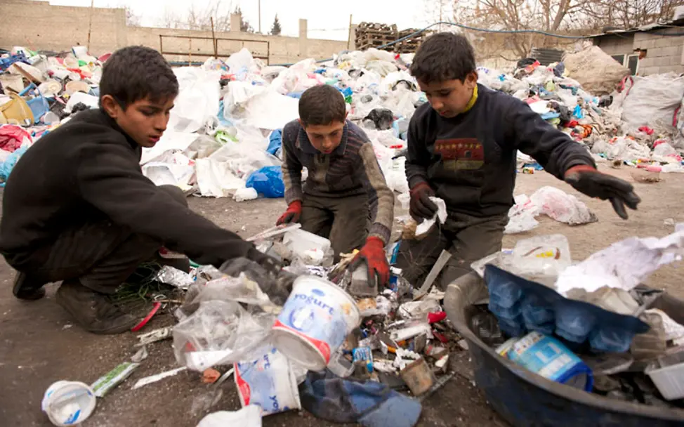 Auf den Knien müssen die Jungs den Müll trennen | © UNICEF/Noorani Kinderarbeit: Hier trennen die Jungs den Müll nach Material.