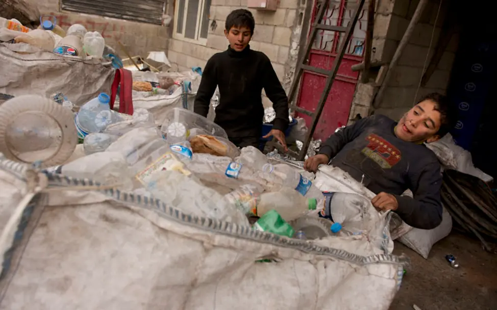 Ahmed zieht den bis zu 100 Kilo schweren Müllsack | © UNICEF/Noorani Kinderarbeit: Nach dem Trennen muss Ahmed noch den schweren Sack lagern
