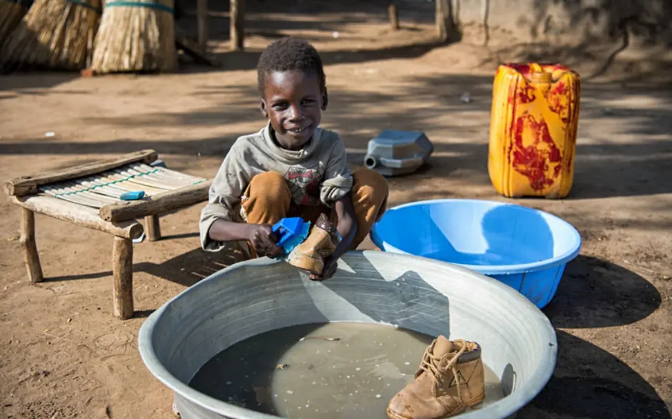 Sabri ist stolz auf seine Schuhe aus Juba | © UNICEF/Everett Südsudan: Sabri wäscht seine Schuhe aus der Hauptstadt Juba