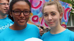 Zweu Jugendliche die sich für UNICEF engagieren lächeln in die Kamera.