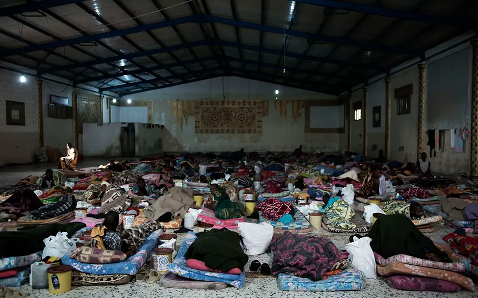 Flüchtlinge in Libyen leben unter erschreckenden Verhältnissen. | © UNICEF/Romenzi Flüchtlinge liegen in einem ehemaligen Jugendgefängnis auf Matratzen.