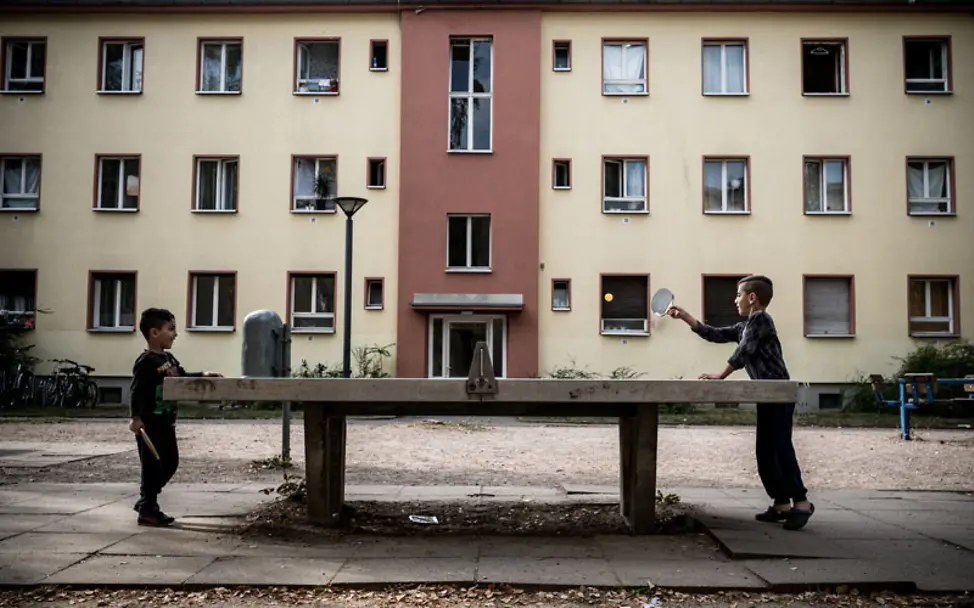 UNICEF-Studie Flüchtlingskinder: Geschwister beim Tischtennisspielen im Hof einer Flüchtlingsunterkunft