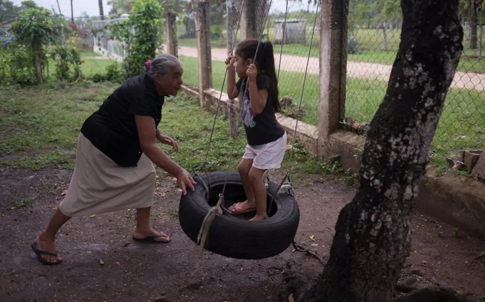 Im Garten spielt Allizon mit ihrer Urgroßmutter | © UNICEF/LeMoyne Belize: Conzuelo spielt mit ihrer Urenkelin auf einer selbstgemachten Schaukel