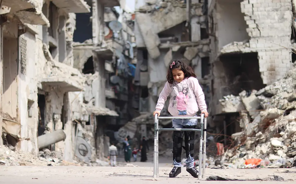 Rama aus Aleppo ist nach einem Bombenangriff auf eine Gehhilfe angewiesen | © UNICEF/ Khudr Al-Issa Syrien-Krieg: Mädchen Rama bewegt sich mithilfe einer Gehhilfe durch das zerstörte Aleppo