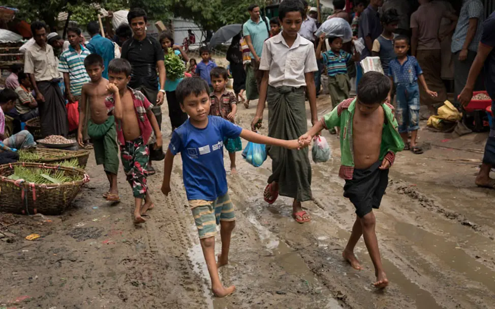 Rohingya Flüchtlingscamp: Omer hilft Mohammed durch den Schlamm | © UNICEF/Brown Rohingya Flüchtlingscamp: zwei Jungs laufen durch Schlamm