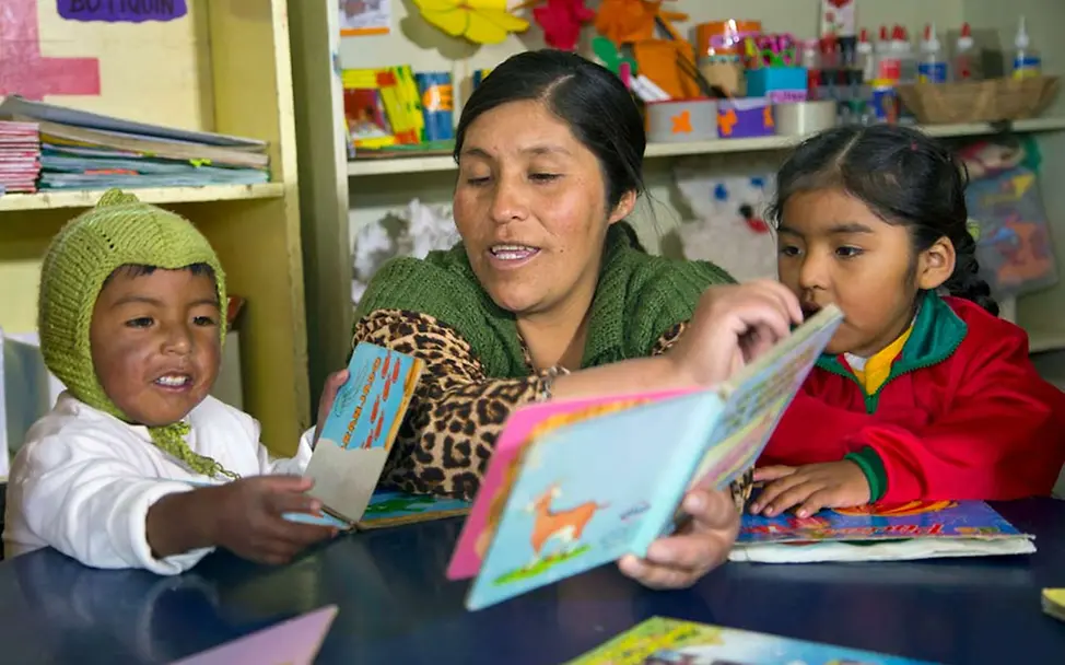 Vorlesen stärkt die kognitive Entwicklung der Kinder | UNICEF/Duranboger Eine Erzieherin liest Kindern in indigener Sprache vor.