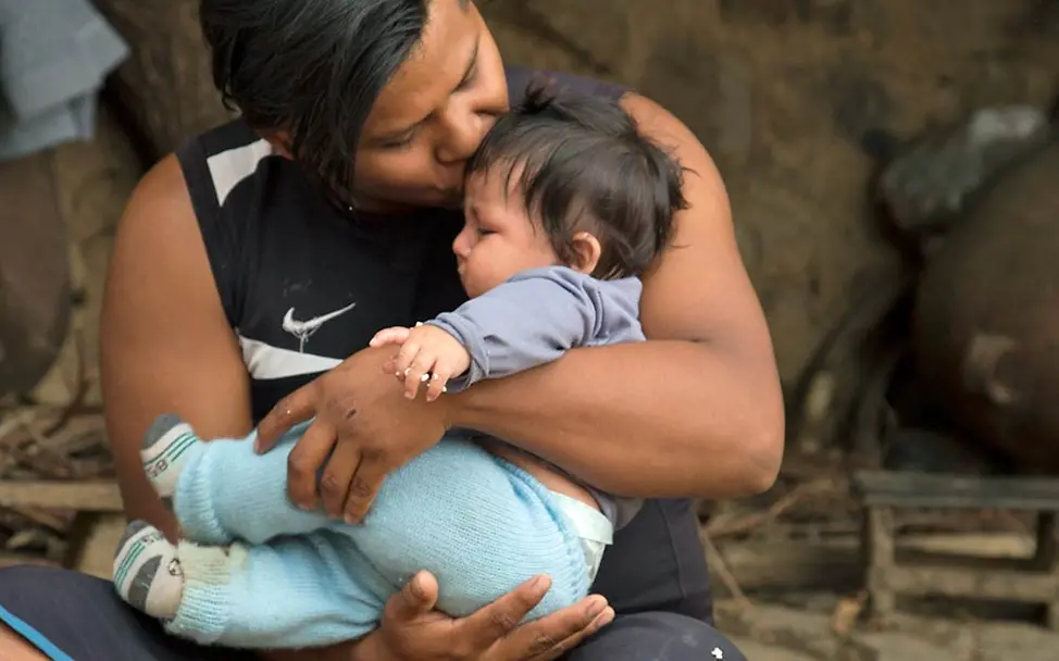 Ein indigener Bolivianer kuschelt mit seinem Baby. | UNICEF/Duranboger Nähe und Körperkontakt sind unendlich wichtig für eine gesunde Entwicklung des Kindes.