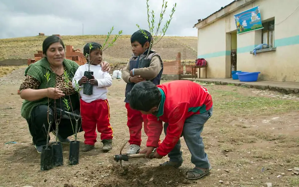 Eine Pädagogin bei der Gartenarbeit mit kleinen Kindern. | © UNICEF/Duranboger Bolivien: Indigene Kinder lernen spielerisch etwas über ihre Umwelt.
