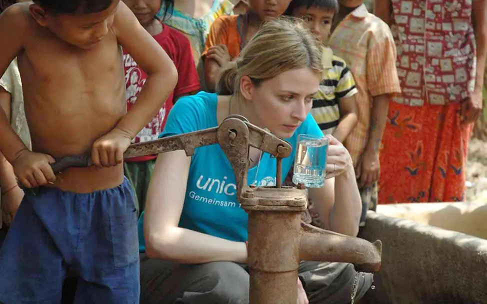 Eva Padberg trinkt Wasser aus einer Filteranlage | © UNICEF/Claudia Berger Kambodscha: Eva Padberg trinkt Wasser aus einer Filteranlage (© UNICEF Deutschland/Claudia Berger)