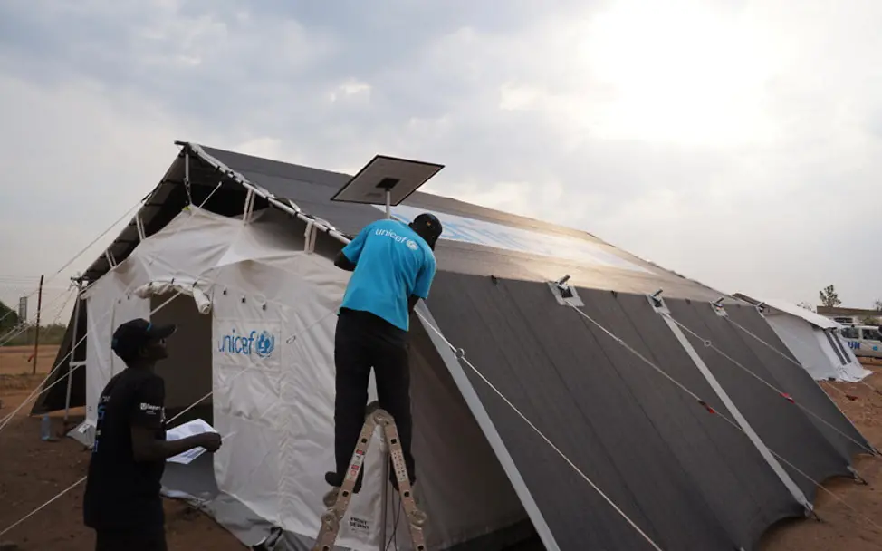Hilfsgüter in Uganda: Die Solaranlage des neuen Zeltes wird installiert. 