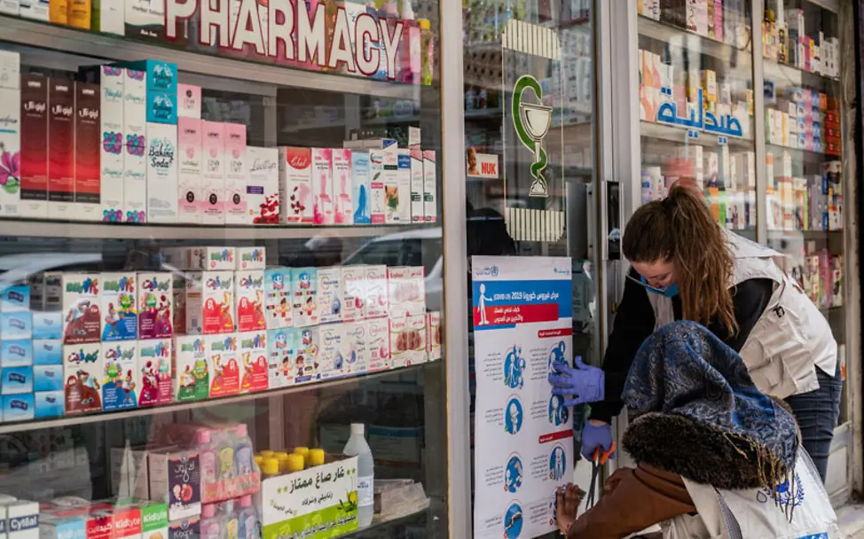 Die Plakate geben Tipps über den richtigen Umgang mit dem Coronavirus | © UNICEF/Souleiman UNICEF-Mitarbeiter hängen Plakate mit wichtigen Informationen auf | © UNICEF/UNI318629/Souleiman