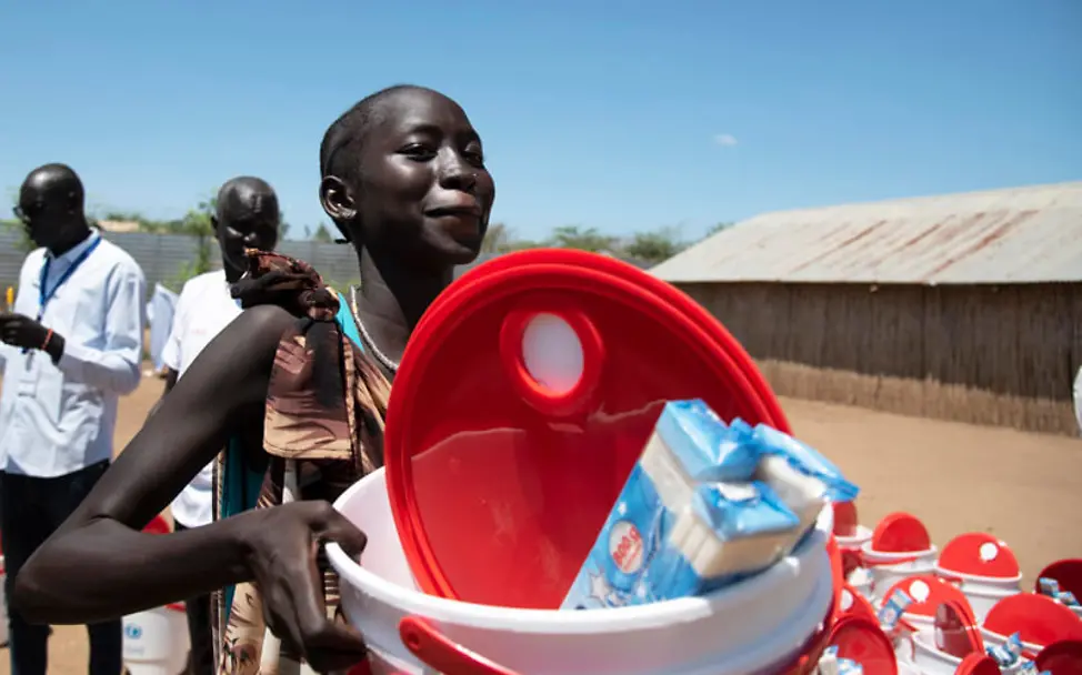Corona: Im Südsudan bekommt eine Frau Wassereimer und Seife von UNICEF | © UNICEF/Ryeng Corona: Im Südsudan bekommt eine Frau Wassereimer und Seife von UNICEF