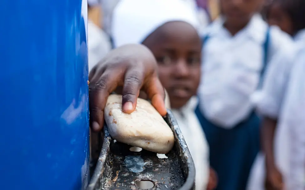 Ein Schüler während des Global Handwashing Day in Beni. | © UNICEF Kongo: Ein junger Schüler wäscht seine Hände mit Seife.