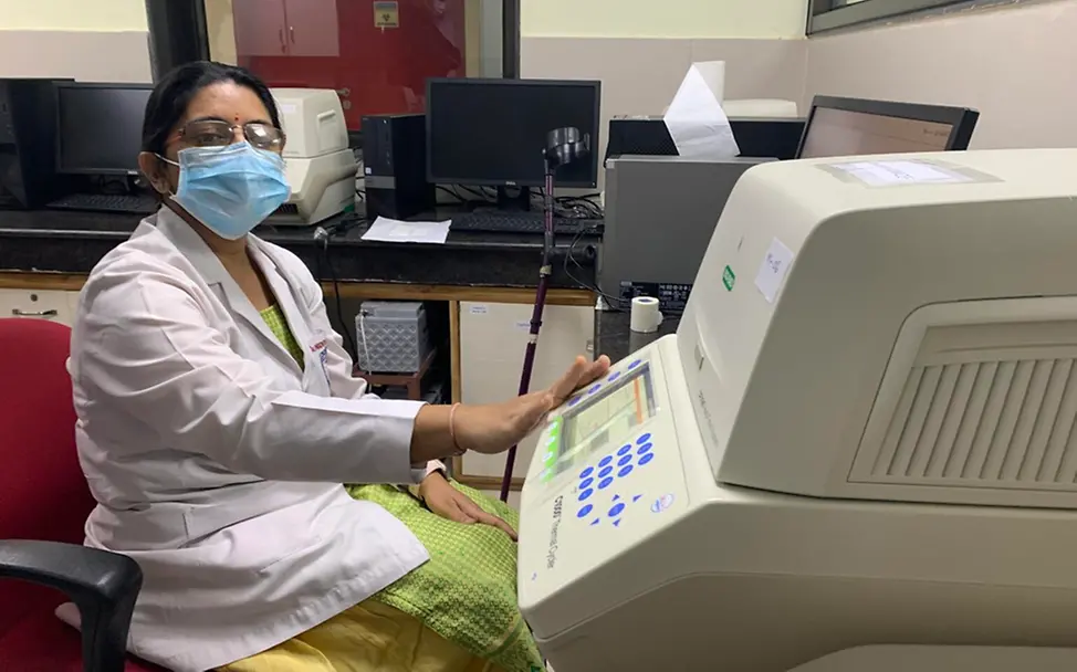 Eine Mitarbeiterin des Virologie-Labors zeigt die Maschine zur Auswertung von PCR-Tests | © UNICEF/India Country Office Corona in Indien: Eine Mitarbeiterin des Virologie-Labors zeigt die Maschine zur Auswertung von PCR-Tests
