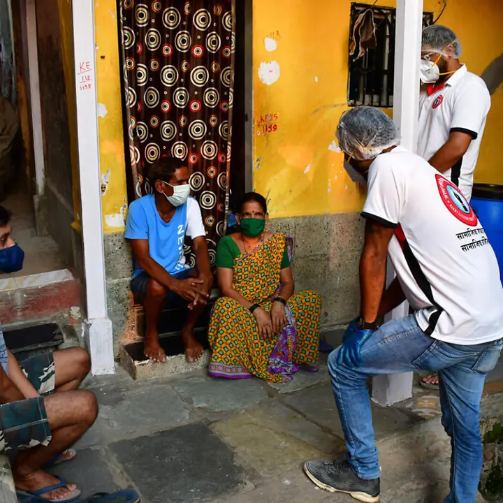 Helfer erklären einer Familie, wie sie sich schützen kann | © UNICEF/Koyande Corona in Indien: Helfer erklären einer Familie, wie sie sich schützen kann