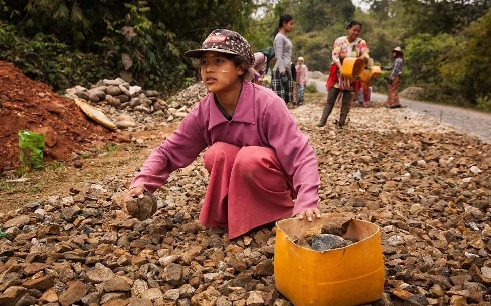 Lieferkettengesetz | © UNICEF/Brown Lieferkettengesetz: In Myanmar sammelt ein Mädchen Steine für den Straßenbau auf.