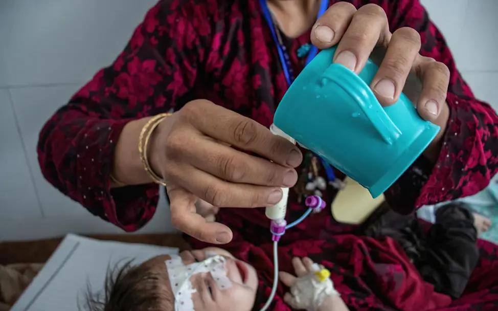 Afghanistan: Eine Helferin versorgt ein mangelernährtes Kind über eine Sonde mit Spezialmilch | © UNICEF/Bidel Afghanistan: Eine Frau versorgt ein mangelernährtes Kind über eine Sonde mit Spezialmilch