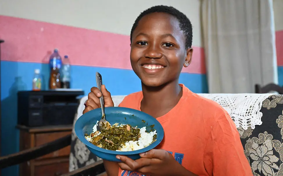 Elfenbeinküste: Ein Junge zeigt sein Lieblingsessen: Reis mit einer Sauce aus Kartoffelblättern | © UNICEF/Diarassouba Elfenbeinküste: Ein Junge zeigt sein Lieblingsessen: Reis mit einer Sauce aus Kartoffelblättern