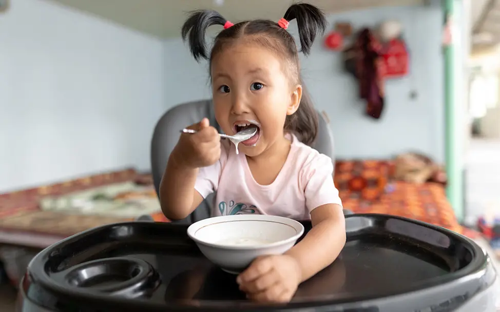 Kirgisistan: Nurayim isst Porridge | © UNICEF/Zhanibekov Kirgisistan: Nurayim isst Porridge