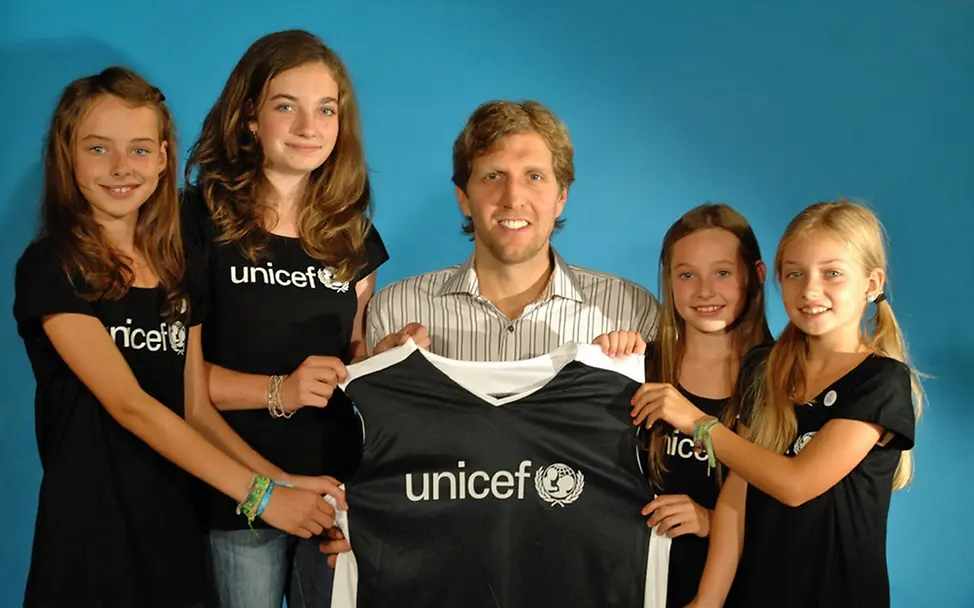 JuniorBotschafterinnen überreichen Dirk Nowitzki ein UNICEF-Trikot. 