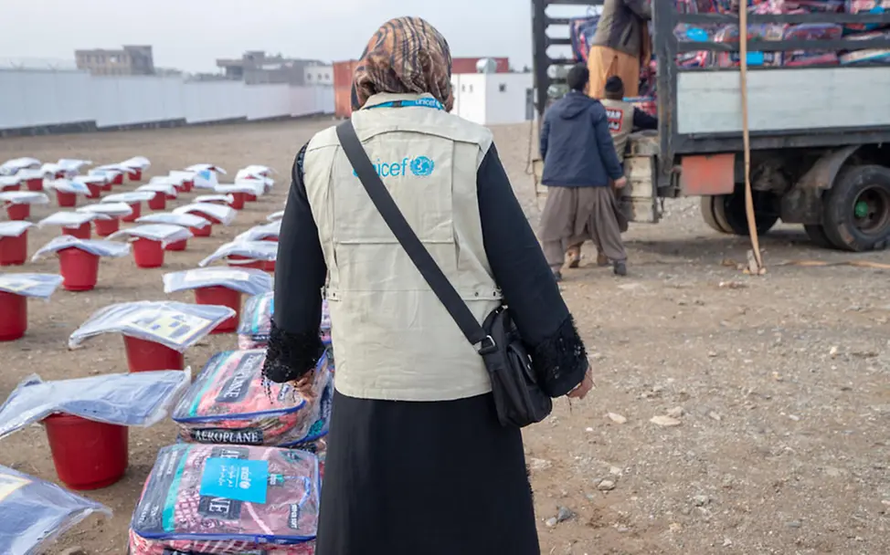 Winter in Afghanistan: Eine UNICEF-Helferin steht neben Decken, die verteilt werden | © UNICEF/Bidel Winter in Afghanistan: Eine UNICEF-Helferin steht neben Decken, die verteilt werden