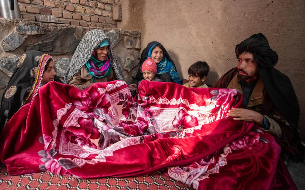 Winter in Afghanistan: Eine Familie hat von UNICEF eine Decke bekommen | © UNICEF/Bidel Winter in Afghanistan: Eine Familie hat von UNICEF eine Decke bekommen