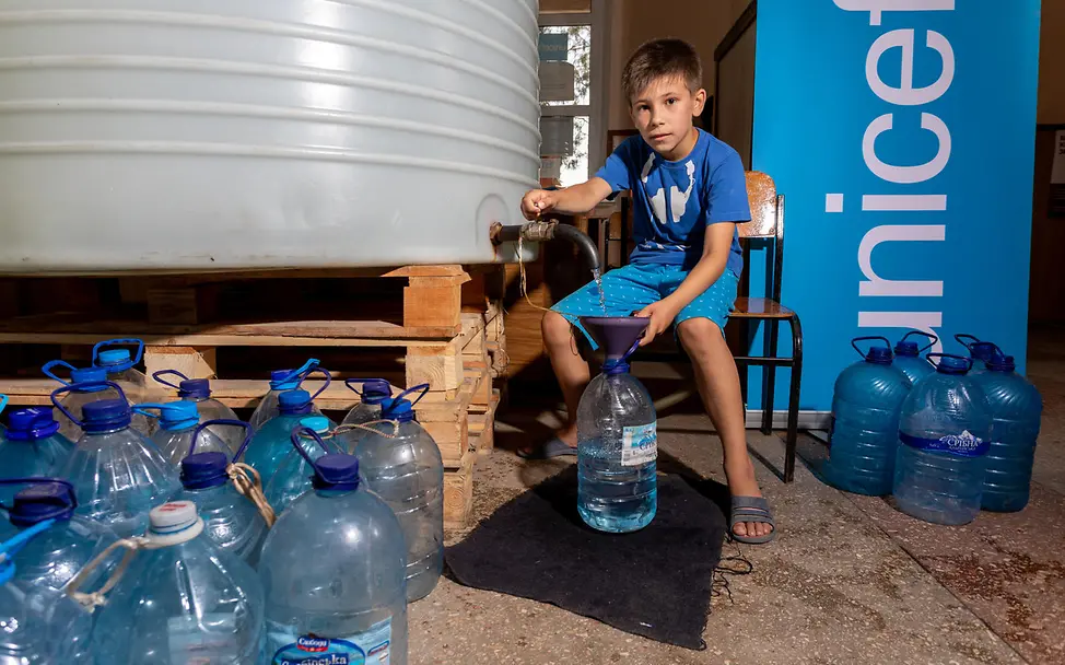 Ukraine-Krieg Verlauf: David, acht Jahre alt, hilft beim Abfüllen von 5-Liter-Plastikflaschen.