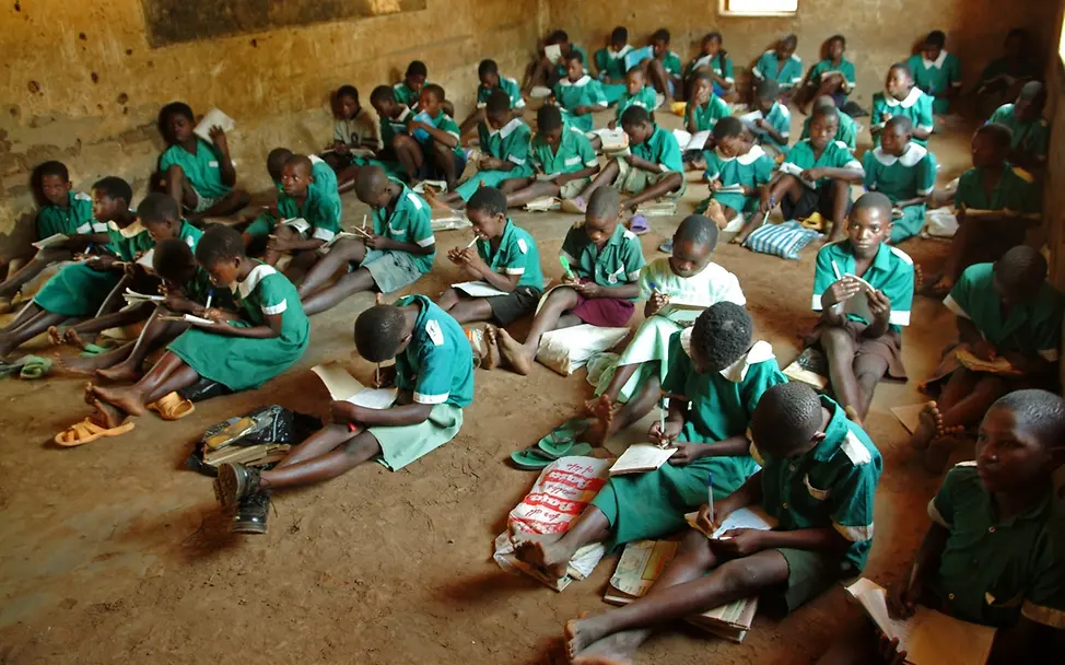 Malawi: Unterricht in einem einfachen Schulgebäude. | © UNICEF Schulen in Afrika: Kinder sitzen in ihren Schuluniformen auf dem Boden eines einfachen Schulgebäudes.
