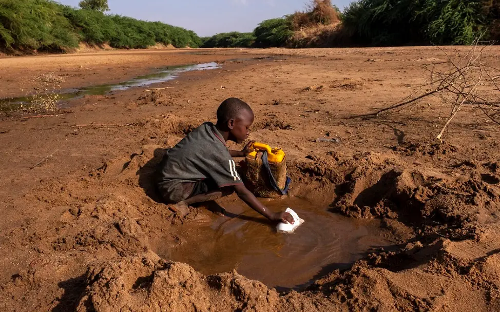 Foto-Reportage: Dürre am Horn von Afrika | © UNICEF/Rich Somalia: Junge sammelt Wasser in einer Pfütze.