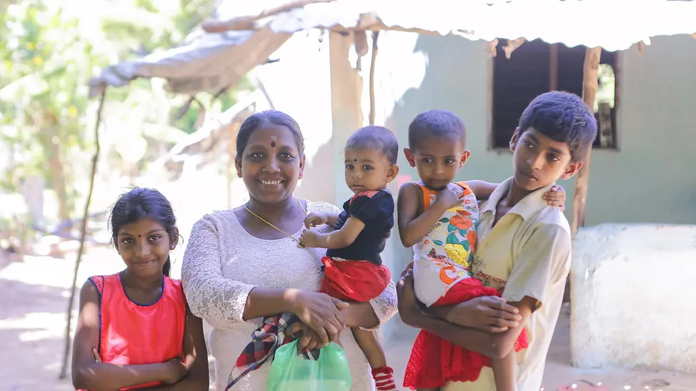 Logeshwari und ihre Familie. | © UNICEF Sri Lanka Die gesamte Familie steht vor ihrem Haus in Sri Lanka.