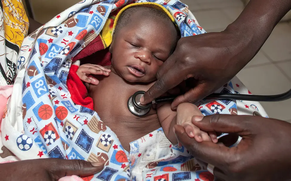 Ein Baby im Südsudan wird mit einem Stethoskop untersucht. 
