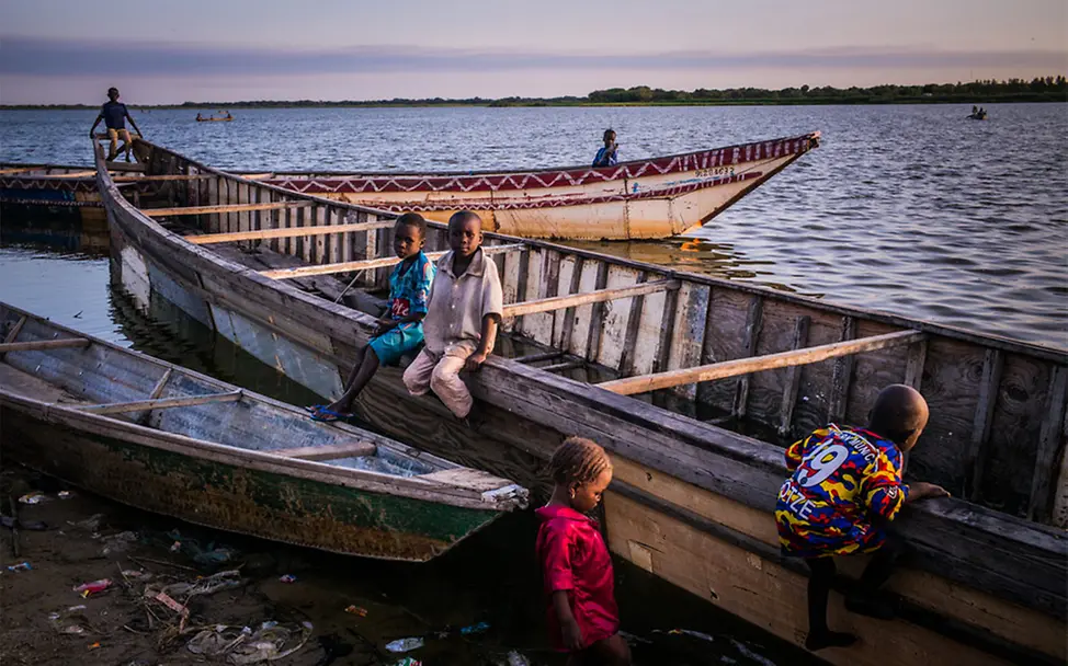 klimawandel folgen kinder: Kinder aus Tschad sitzen auf einem Boot.
