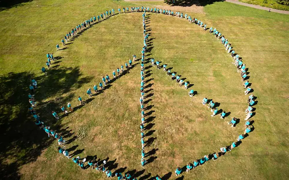 UNICEF-Sommercamp: Engagierte bilden Peace-Zeichen | © Norbert Krause UNICEF-Sommercamp: Engagierte bilden Peace-Zeichen