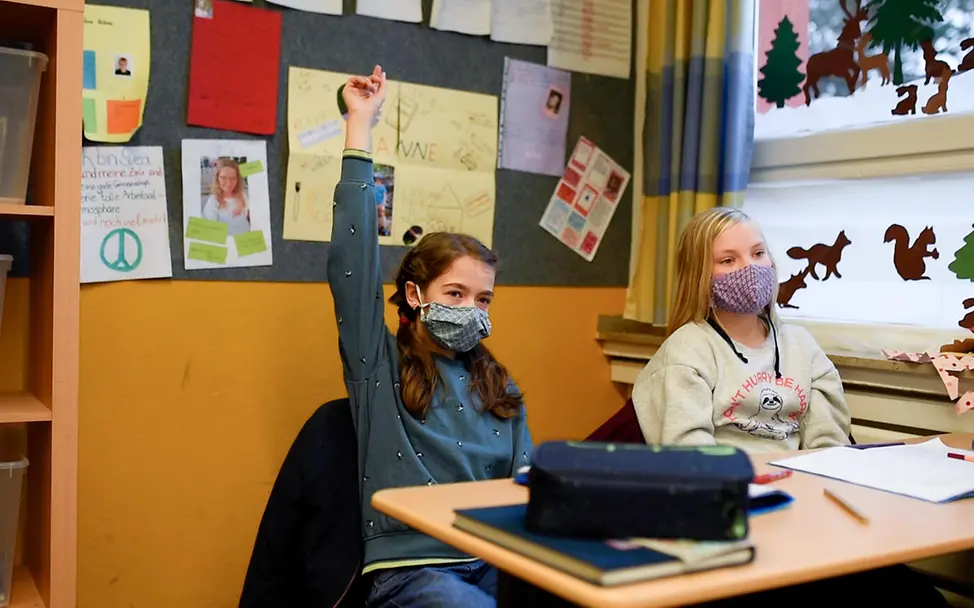 Zurück in die Schule nach dem ersten Lockdown 2020. | © UNICEF/Unruh Ein Mädchen zeigt während des Unterrichts auf.