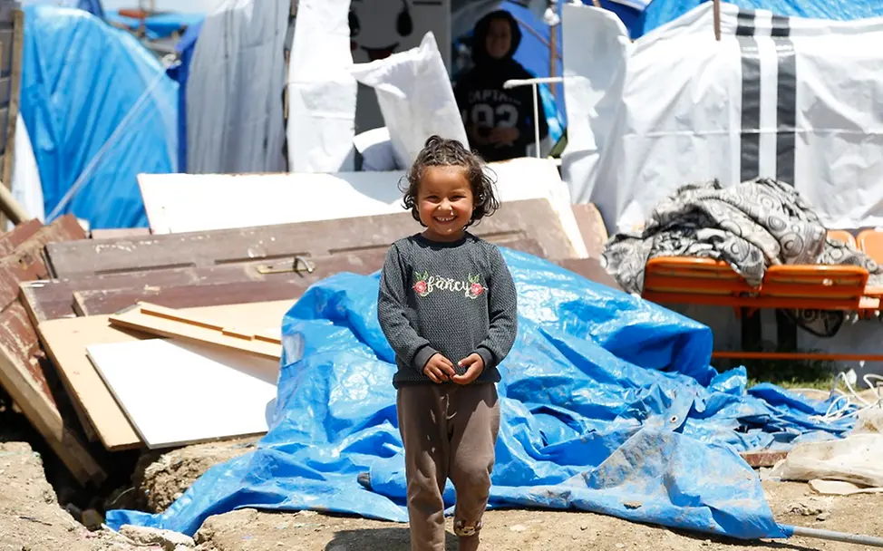Millionen Kinder in der Türkei und in Syrien weiter in verzweifelter Lage I UNICEF/Kiliç Türkei: Ein kleines Mädchen steht vor einem Zelt.