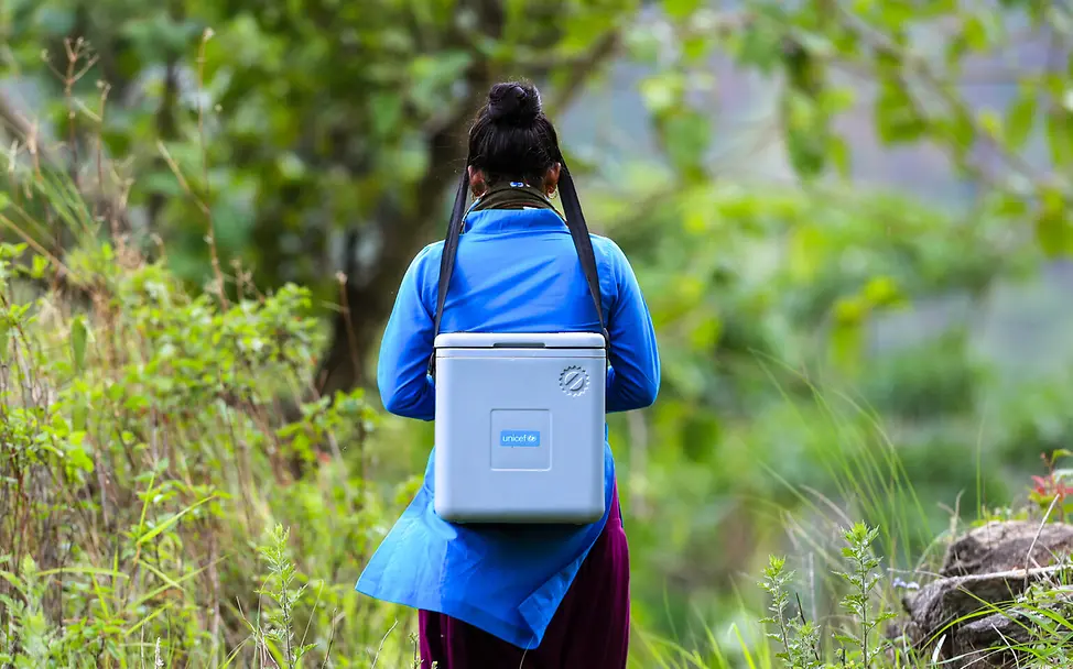 In viele entlegene Gebiete kommen Gesundheitskräfte nur zu Fuß! | © UNICEF/U.S. CDC/Unique Identifier/Laxmi Prasad Ngakhusi Eine Gesundheitshelferin in Nepal bringt gekühlte Impfstoffe zu Kindern.