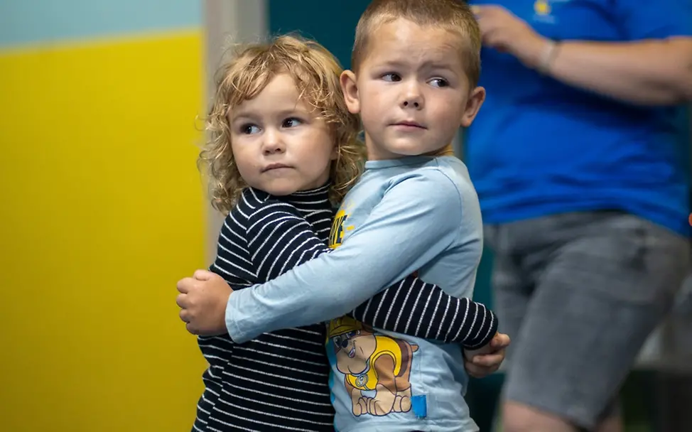 Ein Junge und ein Mädchen umarmen sich im UNICEF Spilno Child Spot in Chuhuiv | © UNICEF/Filippov Weltflüchtlingstag: Ein Junge und ein Mädchen umarmen sich im UNICEF Spilno Child Spot in Chuhuiv.