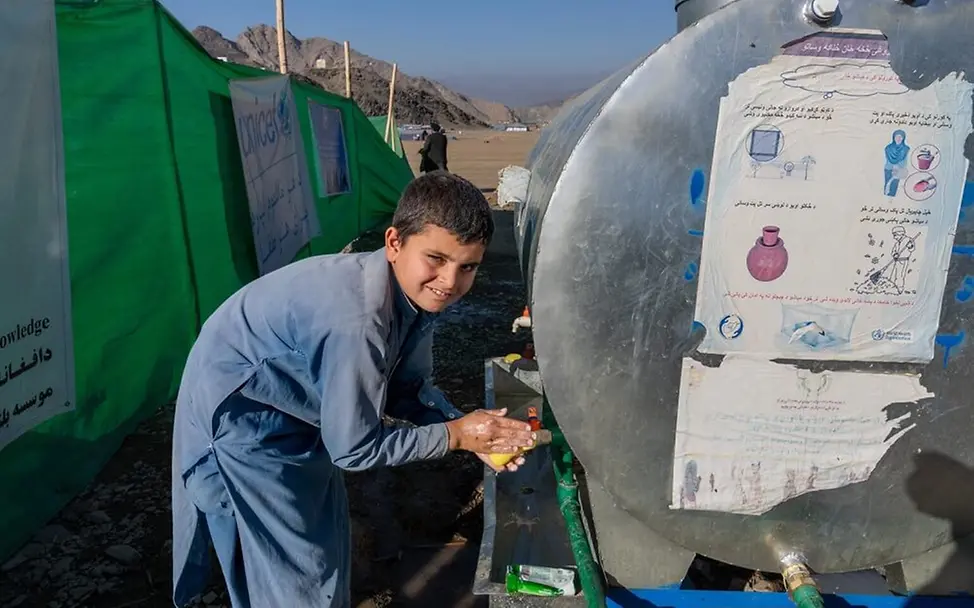 Masern gefährlich: Ein Junge holt Wasser aus einem UNICEF-Tank. Sauberes Wasser hilft, Krankheiten vorzubeugen