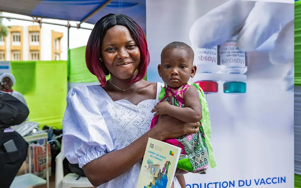 Malaria Kinder schützen: Eine Mutter mit ihrem Baby, das eben gegen Malaria geimpft wurde. 