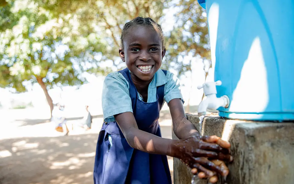 Sambia Wasser: Ein Mädchen wäscht sich an einer UNICEF-Wasserstelle in der Schule die Hände 