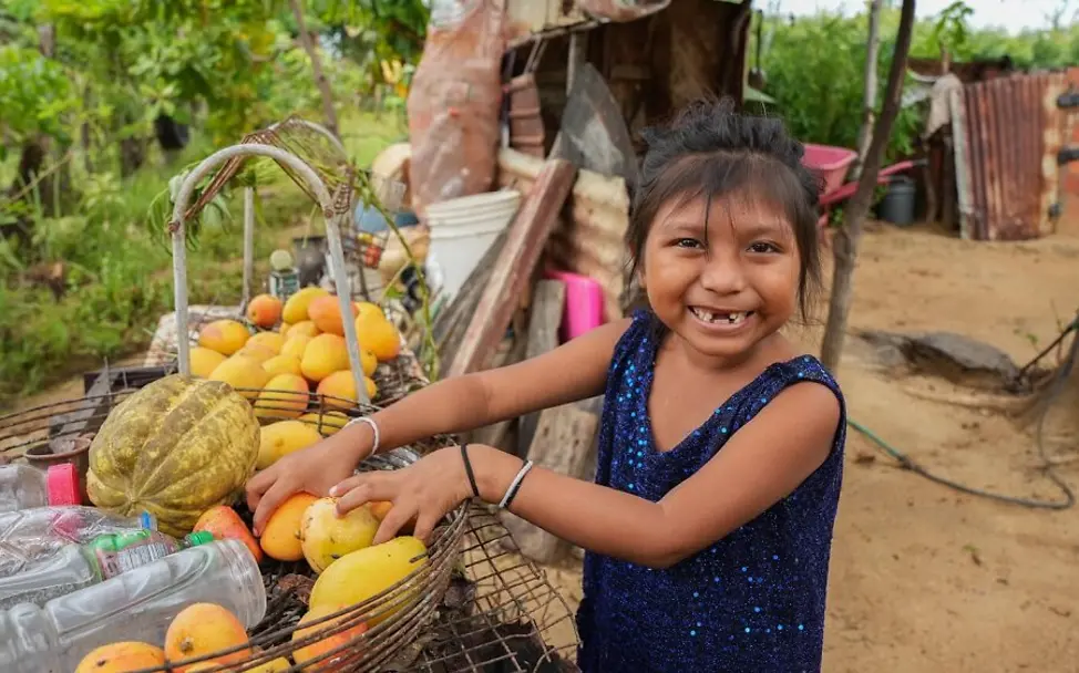 Venezuela: Anita nimmt Obst aus einem Korb. Danke UNICEF hat sie die Mangelernährung besiegt