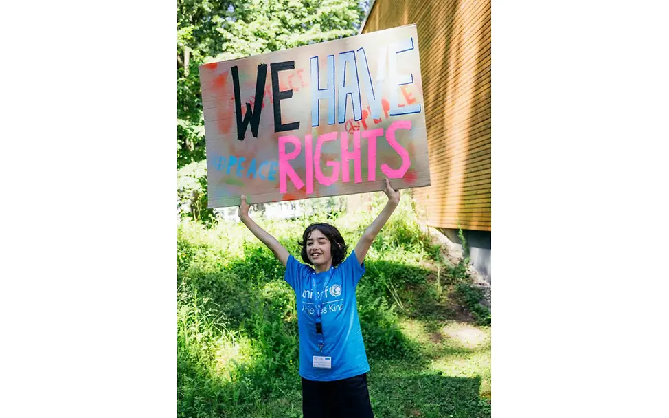 Kind hält "We have rights" Schild.