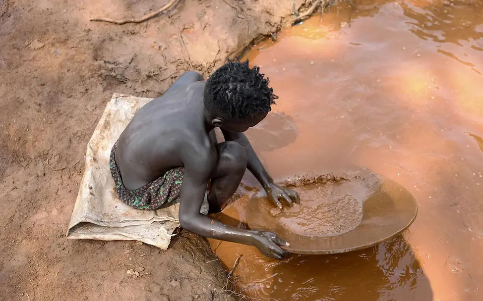 Was kann man gegen Kinderarbeit tun: Ein Junge in Äthiopien schürft an einer Wasserstelle nach Gold. 