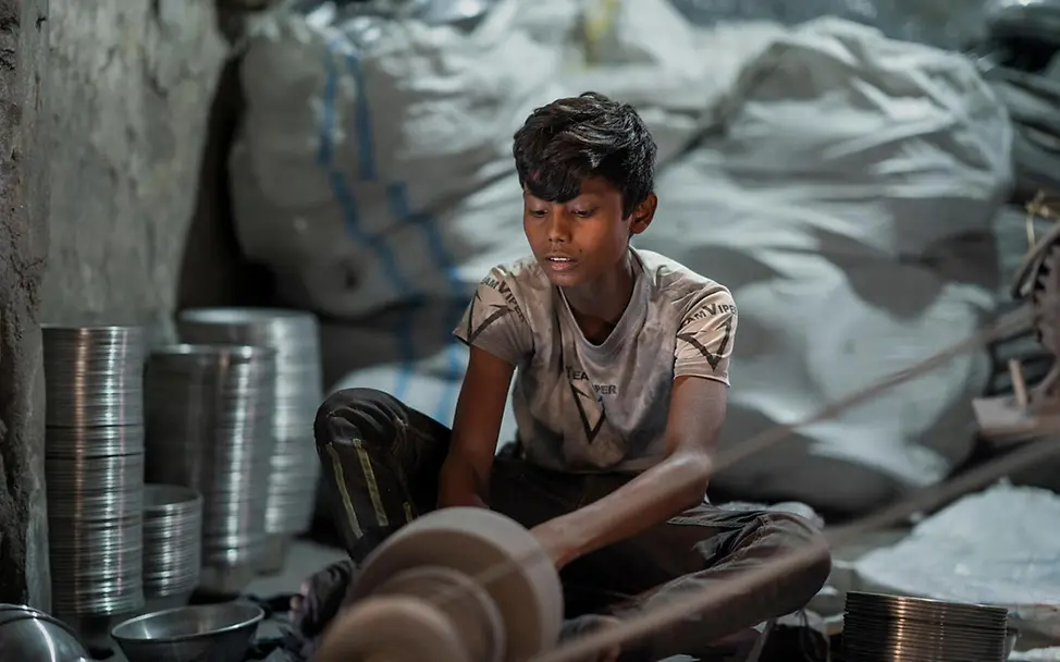 Was kann man gegen Kinderarbeit tun: In einer Fabrik in Bangladesch schuftet ein Junge an einer Maschine und poliert Silber. 