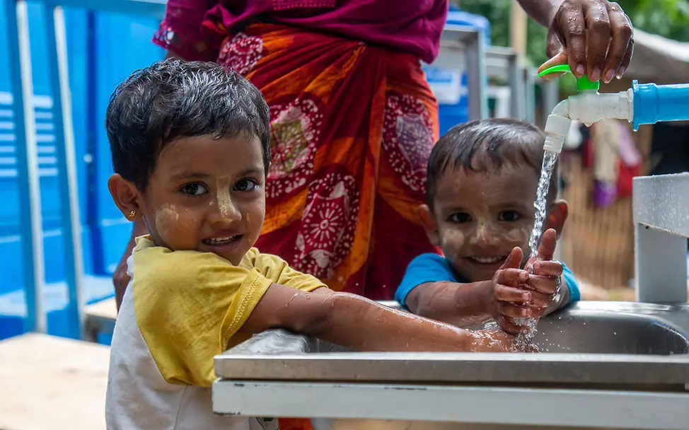 Myanmar Spenden: Kinder waschen sich lächelnd an einem Wasserhahn die Hände. 