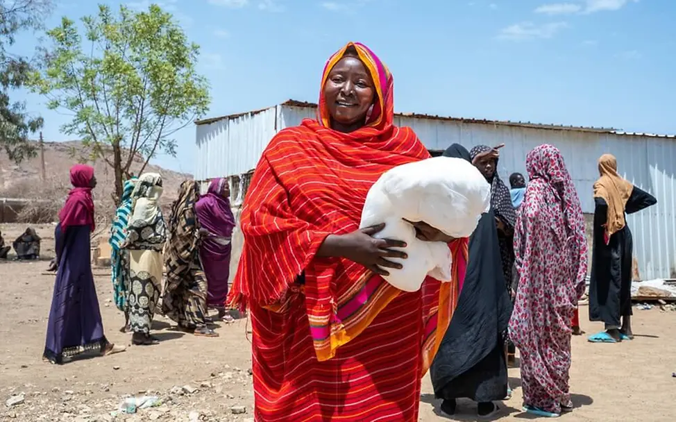 Sudan: Eine Mutter bekommt von UNICEF ein Moskitonetz zum Schutz vor Malaria