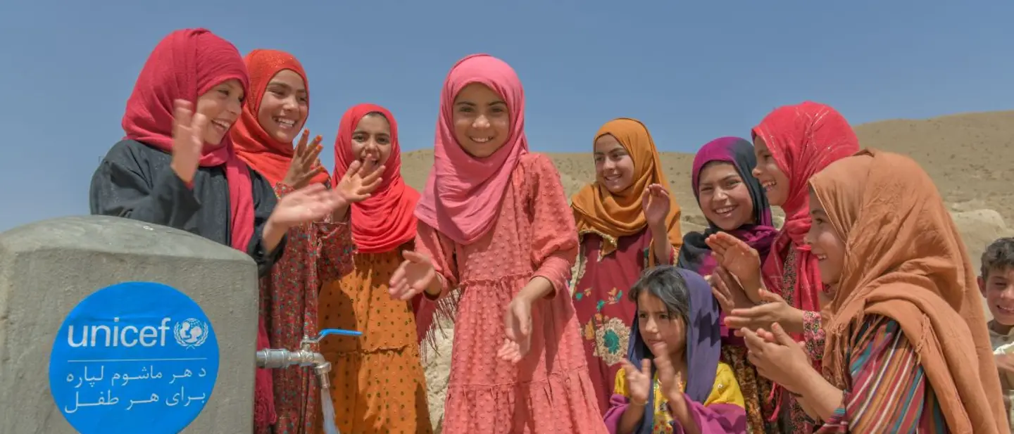 Kinder in Afghanistan stehen um einen Brunnen. 