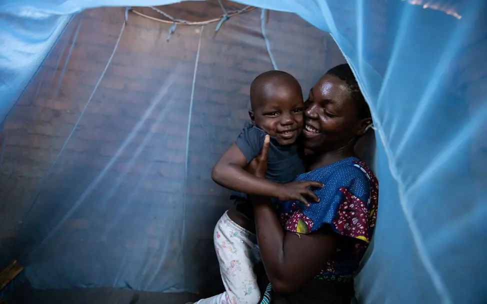 Die 20-jährige Mika hat von UNICEF Hilfsgüter erhalten. Das Moskitonetz schützt sie und ihren 4-jährigen Sohn vor Infektionen.