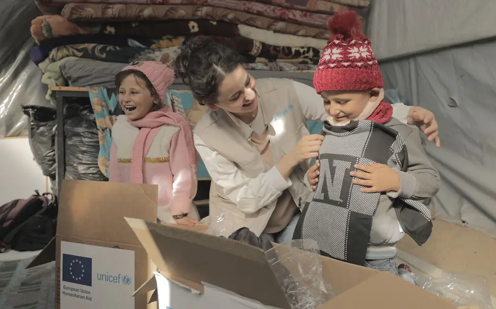 Kinder erhalten von UNICEF wichtige Hilfsgüter: Kleidung für den Winter.