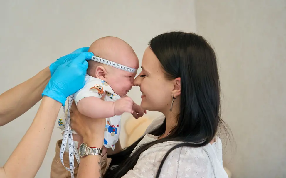 Einem Baby wird der Kopfumfang gemessen. Die Menschen in der Ukraine benötigen Hilfsgüter.